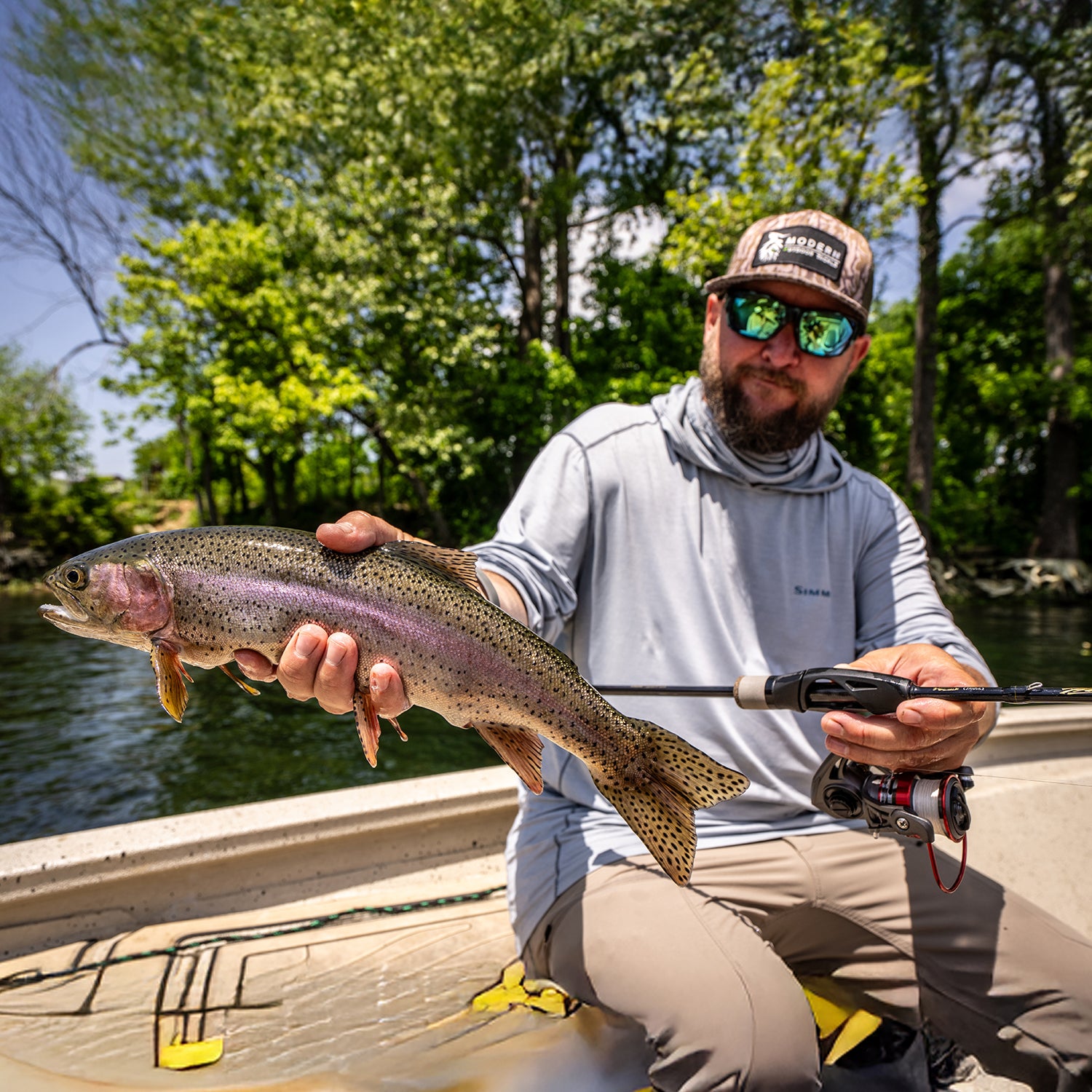 Angler holding trout with ultralight spinning rod